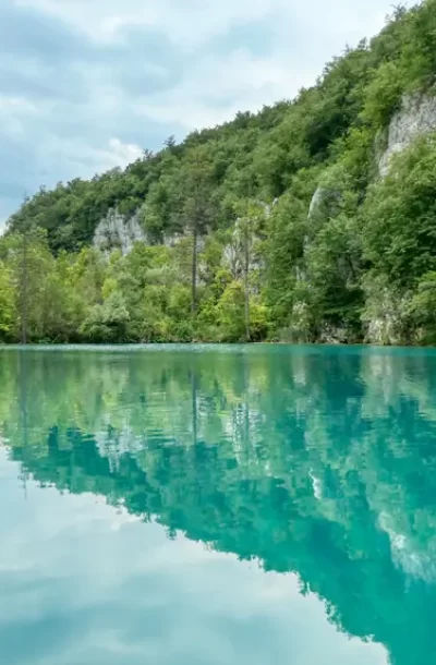 scenic-view-lake-plitvice-by-trees-against-sky.webp